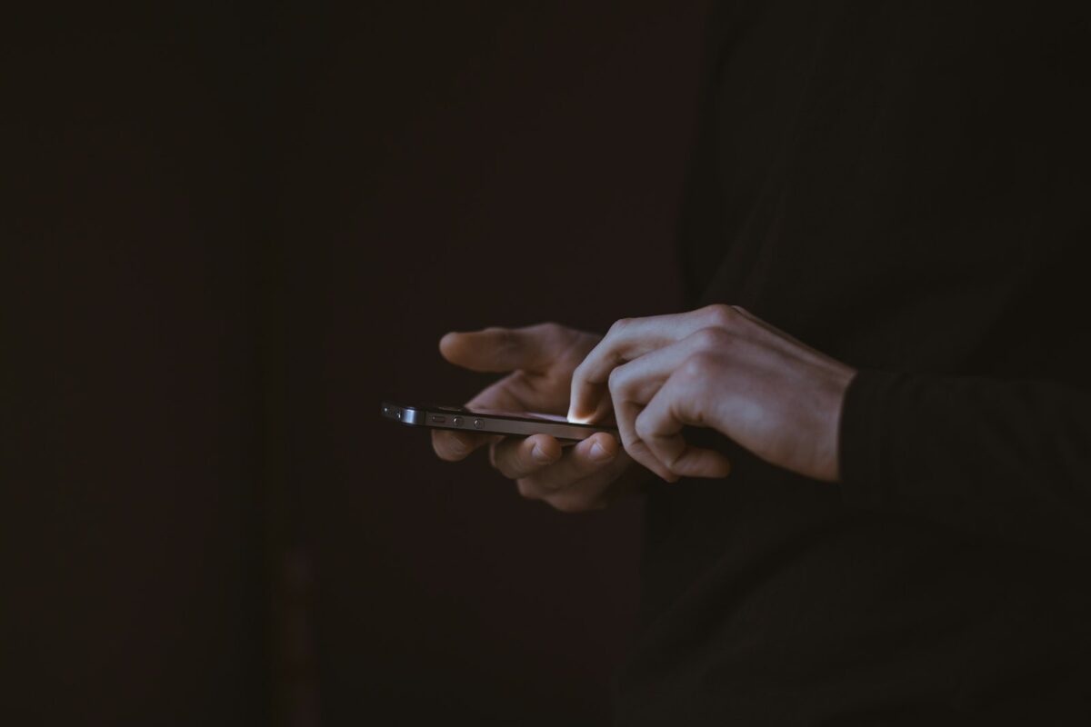Person checking a smartphone message late at night, illustrating out-of-hours customer enquiries