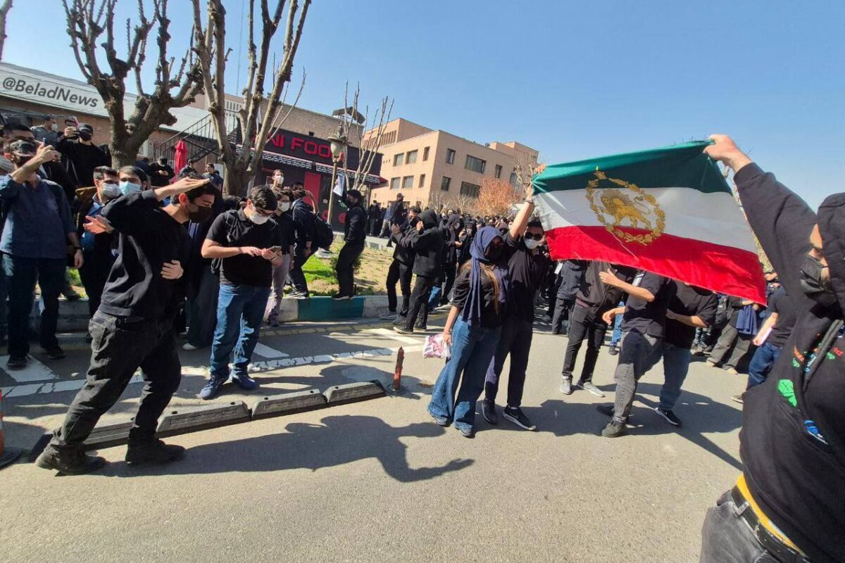 Iranian flag held aloft, as US strikes Kermanshah Iran deepen the conflict