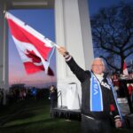 Canada work permit freeze shown through a Canadian flag outside a federal building