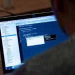 Software developer reviewing PHP code on a laptop after the PHP2Shell critical vulnerabilities disclosure